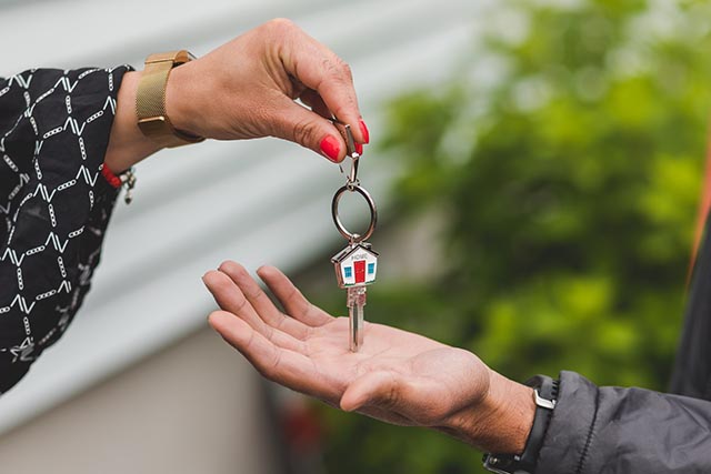 person-holding-out-house-keys-to-another-person